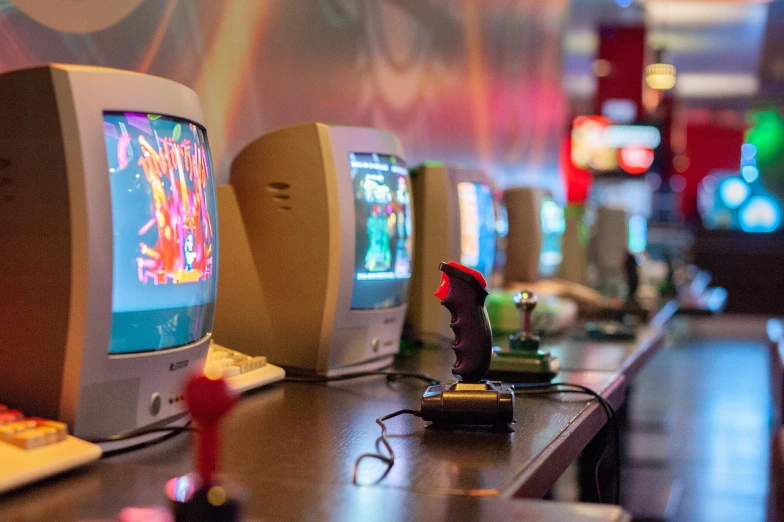 a row of televisions sitting on top of a wooden table, neogeo, charging through a dragons lair, closeup portrait shot, in classic diner, art toys on a pedestal