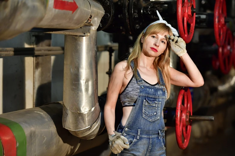 a woman in overalls standing next to a pipe, a portrait, flickr, beutiful white girl cyborg, maintenance area, portrait of a 40 years old women, eighties-pinup style