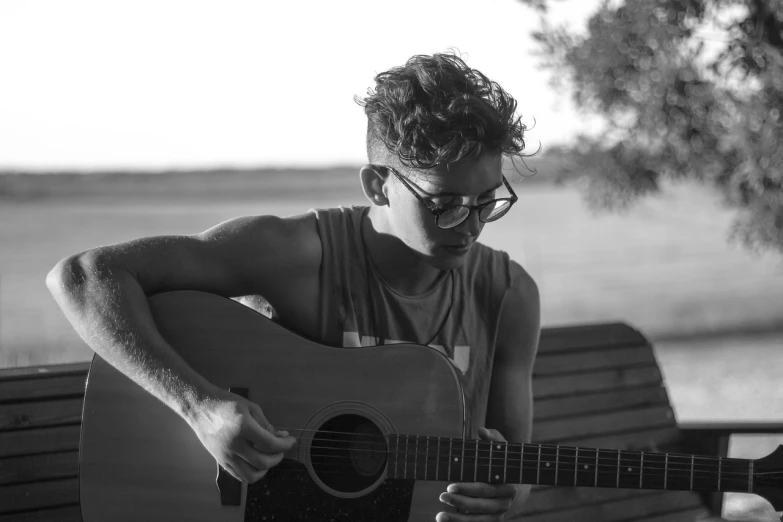 a black and white photo of a man playing a guitar, inspired by Alexis Grimou, pexels, with sunglass, summer setting, ashteroth, beautiful boy