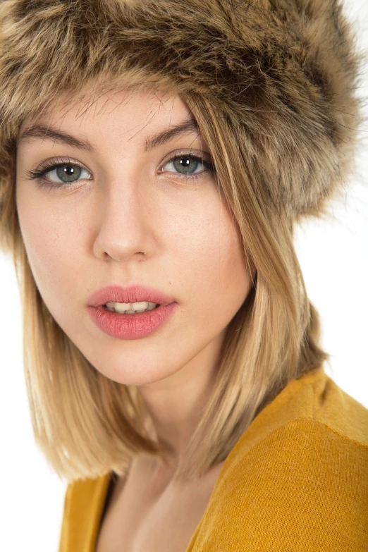 a close up of a woman wearing a furry hat, a portrait, shutterstock, realism, brown-blond-hair pretty face, modern high sharpness photo