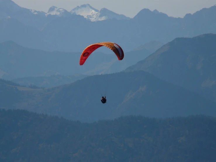 a person that is in the air with a parachute, by Erwin Bowien, flickr, with mountains in the distance, nice colors, vallejo, whistler