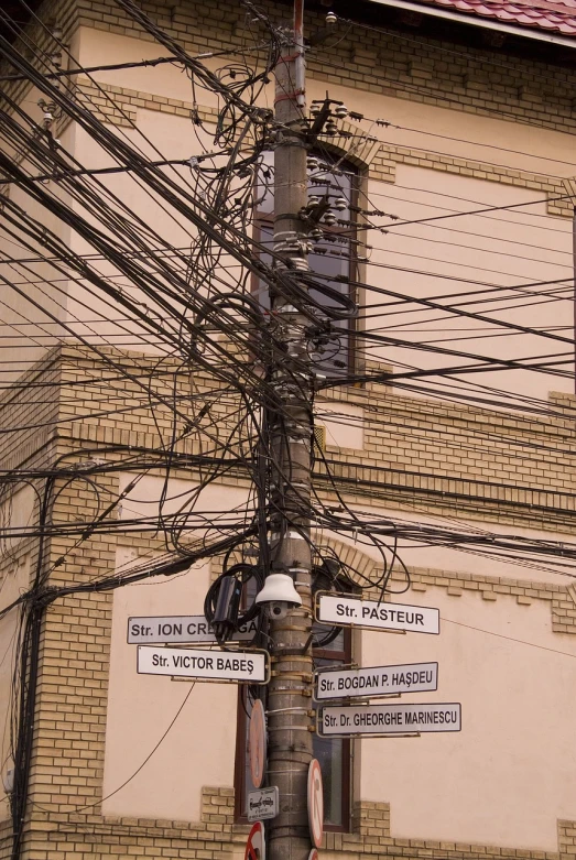 a pole with street signs and wires in front of a building, flickr, dada, intricate wires, orthodox, very very very epic, stacked city