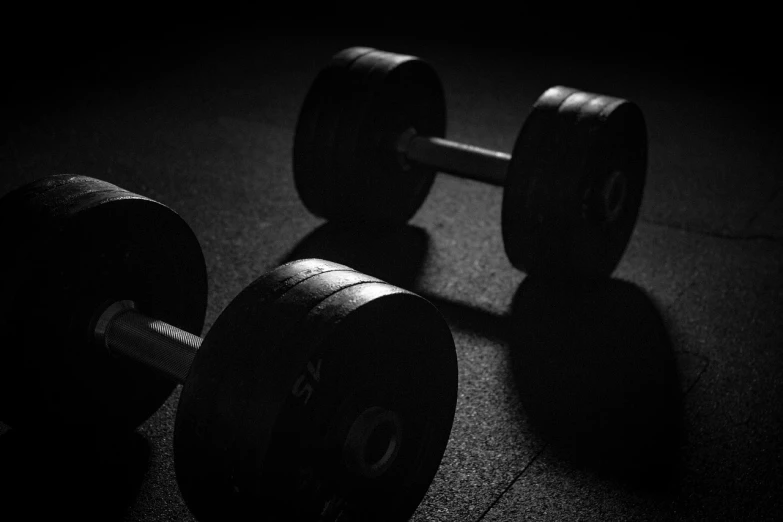 a black and white photo of a pair of dumbbells, by Christen Dalsgaard, strong spotlights, siluettes, wallpaper mobile, wheels