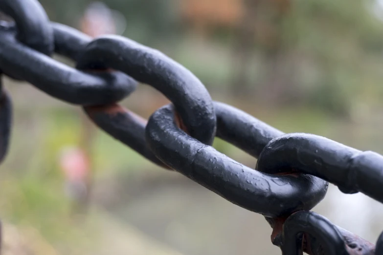 a close up of a chain connected to a fire hydrant, by Jacek Sempoliński, flickr, metal chain and black cape, no blur dof bokeh, painted metal, bent rusted iron