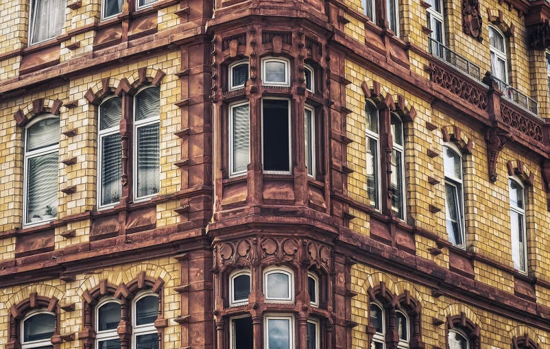 a very tall building with lots of windows, a photo, shutterstock, art nouveau, bay window, 8k 50mm iso 10, brick building, detail texture