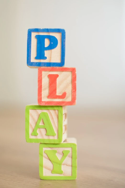 a stack of wooden blocks with the word play written on them, a picture, by Amelia Peláez, pexels, plasticien, show from below, toy room, 4k high res, letter s