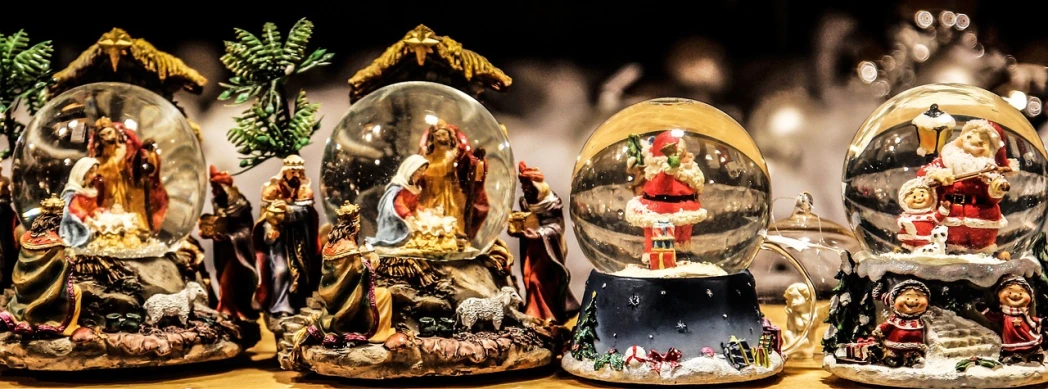 a group of snow globes sitting on top of a wooden table, pixabay, fine art, with infant jesus, half image, ad image, santa