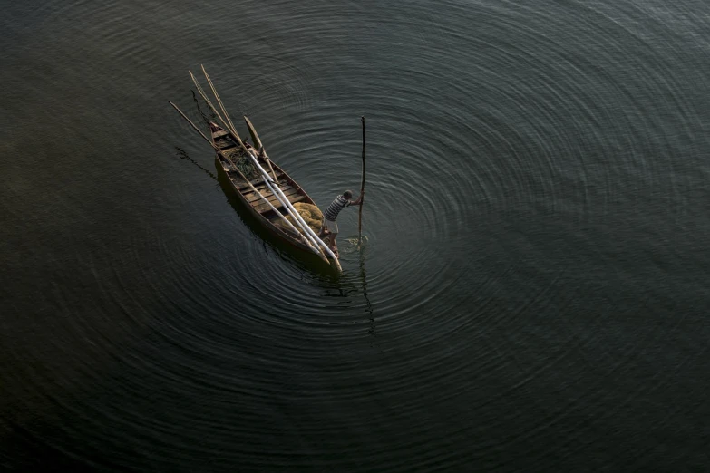 a small boat floating on top of a body of water, by Sunil Das, minimalism, old dhaka, a high angle shot, ap, horn