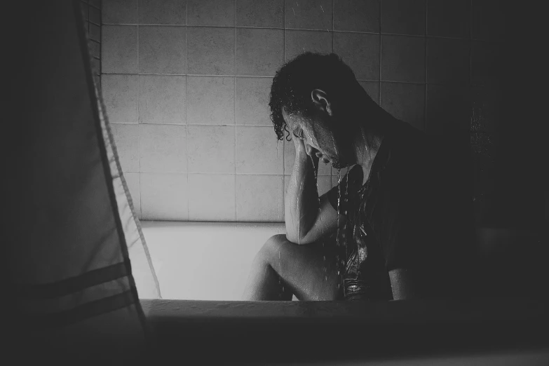 a black and white photo of a man sitting in a bathtub, pexels, people crying, silhouette of man, ptsd, 435456k film