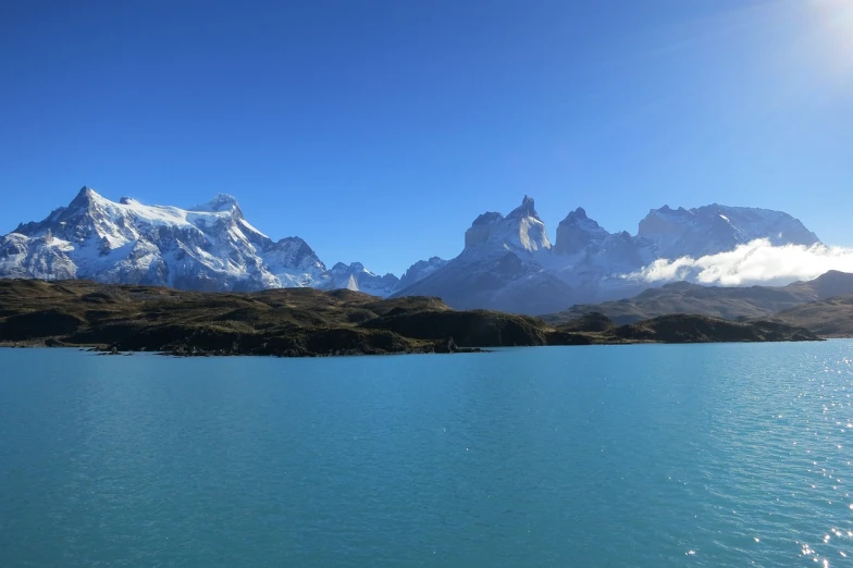 a body of water with mountains in the background, a photo, by Andrei Kolkoutine, patagonian, 4 k cinematic panoramic view, 8k)), clear and sunny