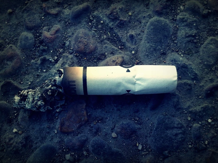 a close up of a cigarette on the ground, inspired by William Harnett, !dream abandoned rocket ship, shot with hasselblade camera, we didn't start the fire, iphone photo
