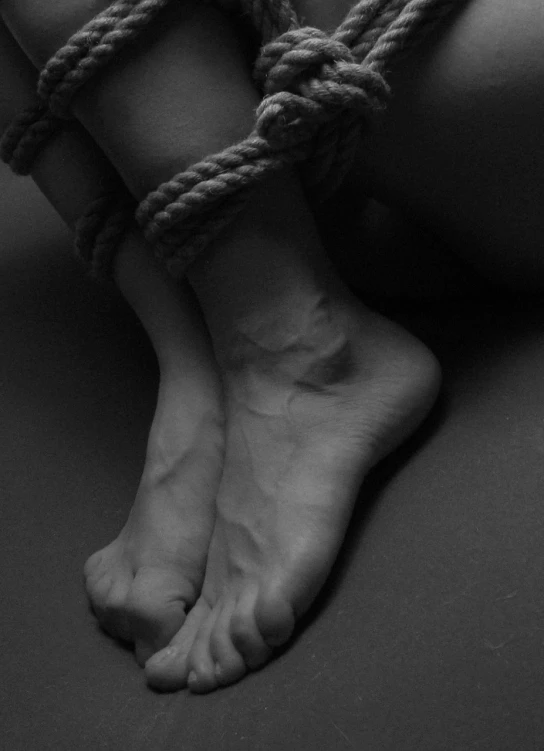 a black and white photo of a person tied up, inspired by Robert Mapplethorpe, tumblr, detailed foot shot, slave collar, simone graci, danila tkachenko