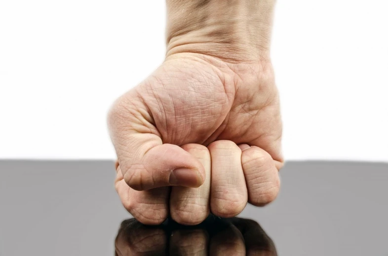 a close up of a person's fist on a table, inspired by Daryush Shokof, shutterstock, auto-destructive art, aggressive stance, фото девушка курит, downward gaze, background is white