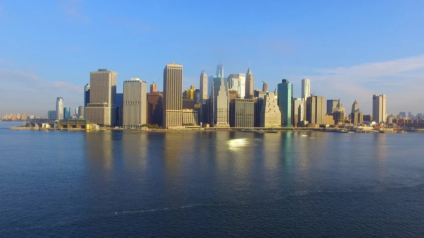 a large body of water with a city in the background, a picture, golden hour in manhattan, video, sunny mid day, 7 7 7 7