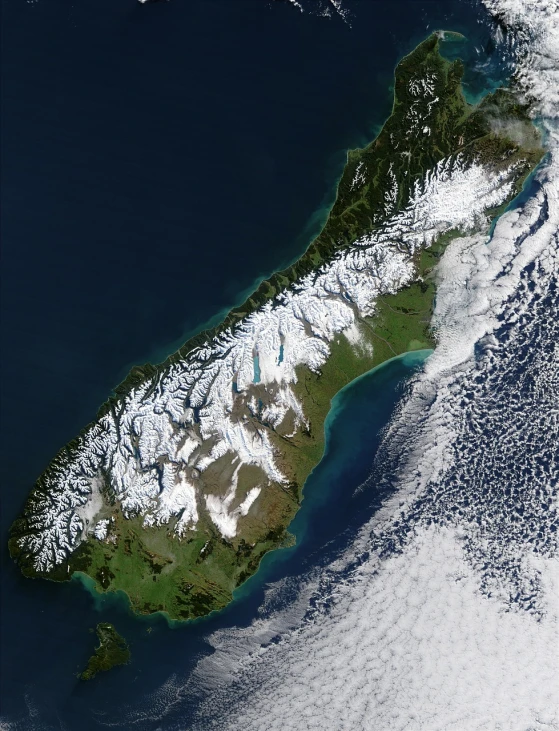 an island in the middle of the ocean, a photo, new zealand landscape, very light snow, nasa photo, integrated in the mountains