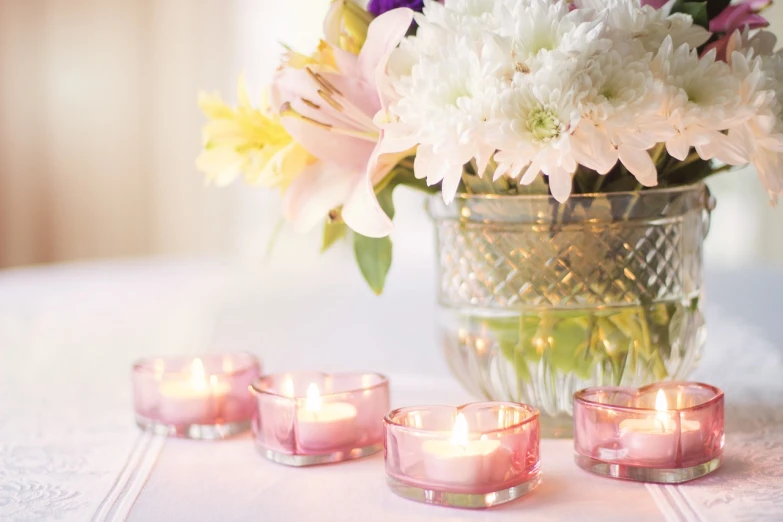 a vase filled with candles sitting on top of a table, by Rhea Carmi, pexels, soft pastel colors, sandra chevier, bouquets, rip