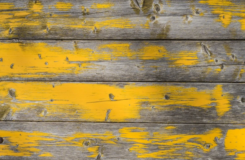 a close up of a wooden surface with yellow paint, by Richard Carline, rustic and weathered, barn, close-up product photo