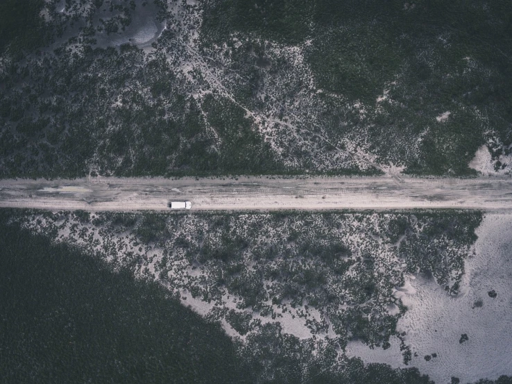 an aerial view of a truck driving down a dirt road, by Karl Buesgen, unsplash contest winner, conceptual art, on the coast, desaturated, symmetrical outpost, high detail photo of a deserted