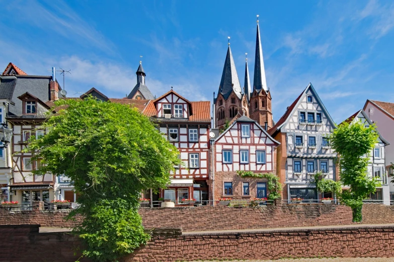 a row of buildings next to a body of water, by Karl Hagedorn, shutterstock, heidelberg school, timbered house with bricks, asymmetrical spires, detmold charles maurice, stock photo