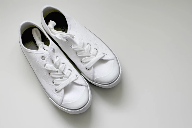 a pair of white sneakers on a white surface, by Kiyoshi Yamashita, minimalism, punpun onodera, easy to use, former, suns
