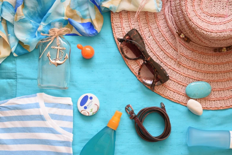 a hat, sunglasses and other items laid out on a table, a picture, shutterstock, plasticien, saltwater, warm spring, blue color theme, miscellaneous objects