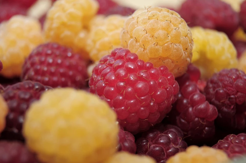 a pile of raspberries sitting on top of each other, a picture, yellow and red color scheme, istockphoto, close establishing shot, mid shot photo