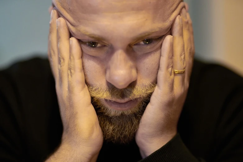 a bald man with his hands on his face, a portrait, inspired by Lajos Vajda, flickr, bearded, she's sad, shot on nikon z9, man in his 30s