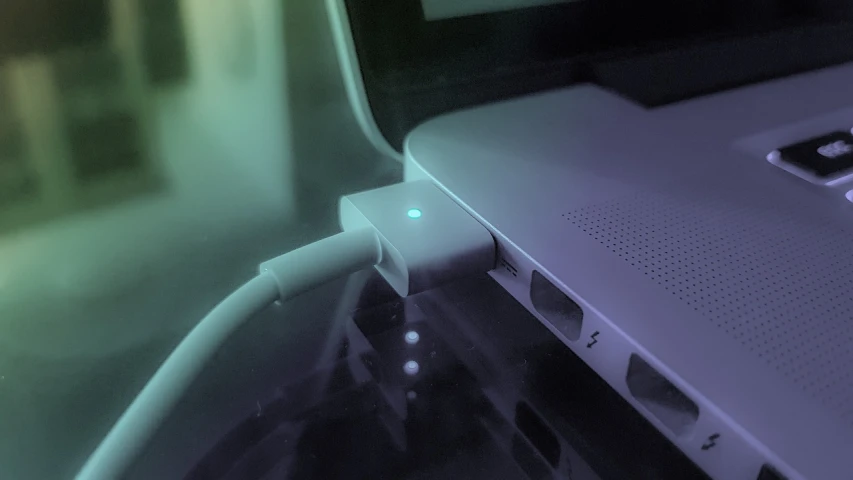 an open laptop computer sitting on top of a desk, by Jason Felix, computer art, charging plug in the chest, cinematic closeup, colorized photon, 3d ios interface design jony ive