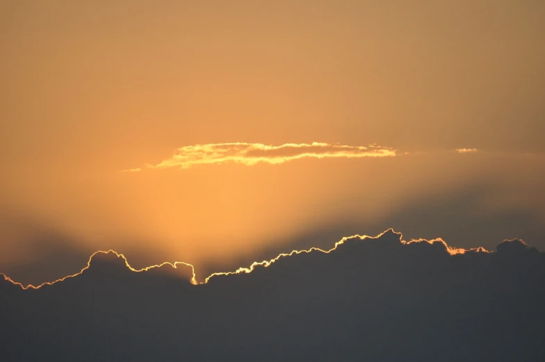 a plane flying in the sky at sunset, a picture, by Linda Sutton, cloud in the shape of a dragon, golden glistening, sunset photo, sunset kanagawa prefecture