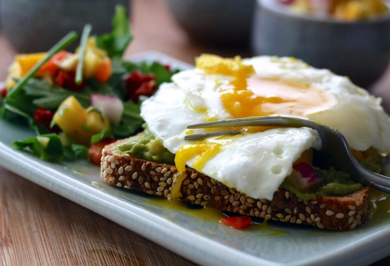 a close up of a plate of food with a fork, by Randy Post, pexels, an egg, avacado dream, toast, sunny light