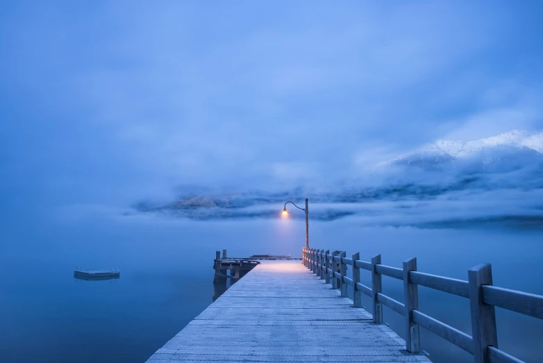 a dock in the middle of a body of water, by Eero Snellman, cold blue light, today\'s featured photograph 4k, midnight mist streetlights, beautiful morning