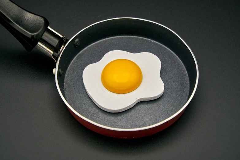 a fried egg in a frying pan on a table, by Jan Rustem, flickr, bauhaus, silicone skin, modeled in 3 d, foam, product introduction photo