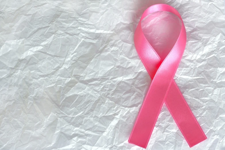 a pink ribbon laying on top of a piece of paper, a picture, plasticien, cas, background focus, disease, beautiful people