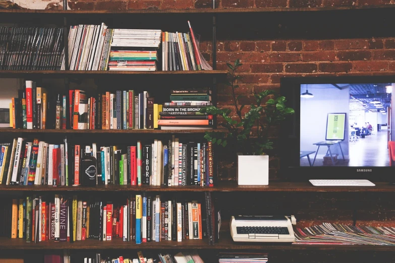 a bookshelf filled with lots of books and a television, a picture, pexels, interior of a loft, snapshot, 3 4 5 3 1, computer aesthetic