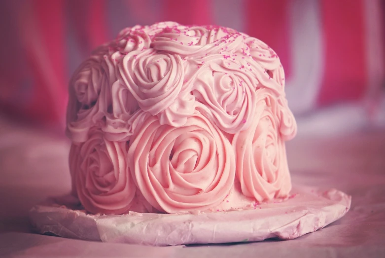 a pink cake sitting on top of a white plate, by Marie Bashkirtseff, tumblr, retro effect, twirls, rosses, close-up shot