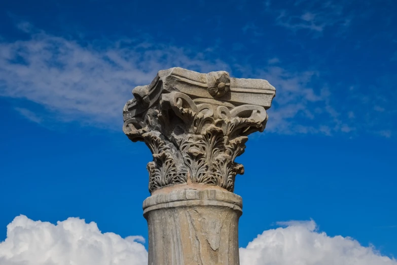a close up of a pillar with clouds in the background, romanesque, pamukkale, acanthus scroll, market in ancient rome, closeup photo