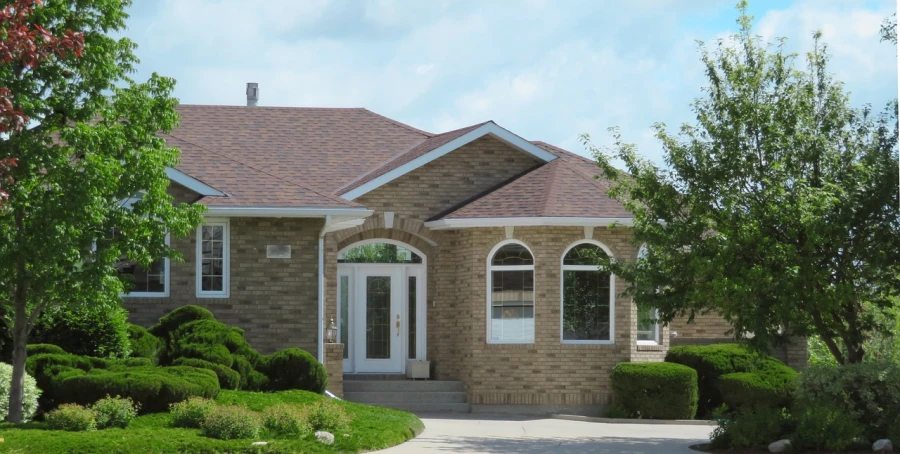 a house with a driveway in front of it, by Dennis Ashbaugh, drumheller, arched ceiling, coper cladding, brick