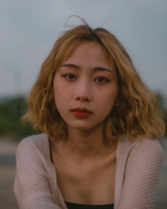 a close up of a person wearing a sweater, a picture, inspired by Elsa Bleda, unsplash, realism, asian girl, with a sad expression, portrait of a blonde woman, south east asian with round face