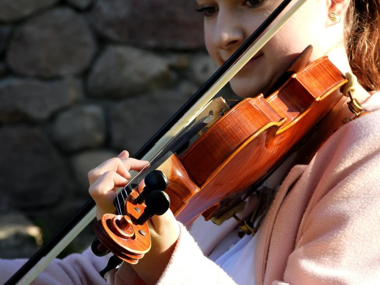 a close up of a person playing a violin, a picture, by Erwin Bowien, pexels, petite girl, stock photo, 3 / 4 view portrait, delightful surroundings