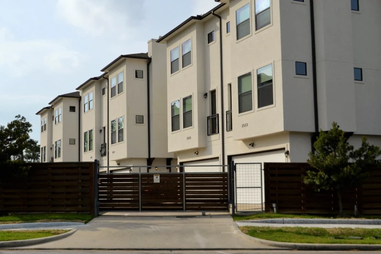 a couple of buildings that are next to each other, by Carey Morris, pixabay, suburban home, gate, ten flats, slight overcast lighting