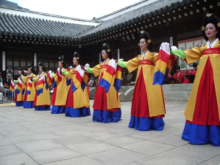 a group of people that are standing in front of a building, inspired by Shin Yun-bok, flickr, palace dance, red yellow blue, beautiful girls, he is dancing