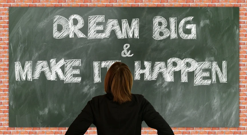 a woman standing in front of a chalkboard that says dream big and make it happen, a picture, inspired by John Maxwell, trending on pixabay, happening, deep dream, she is happy, english, looking upwards