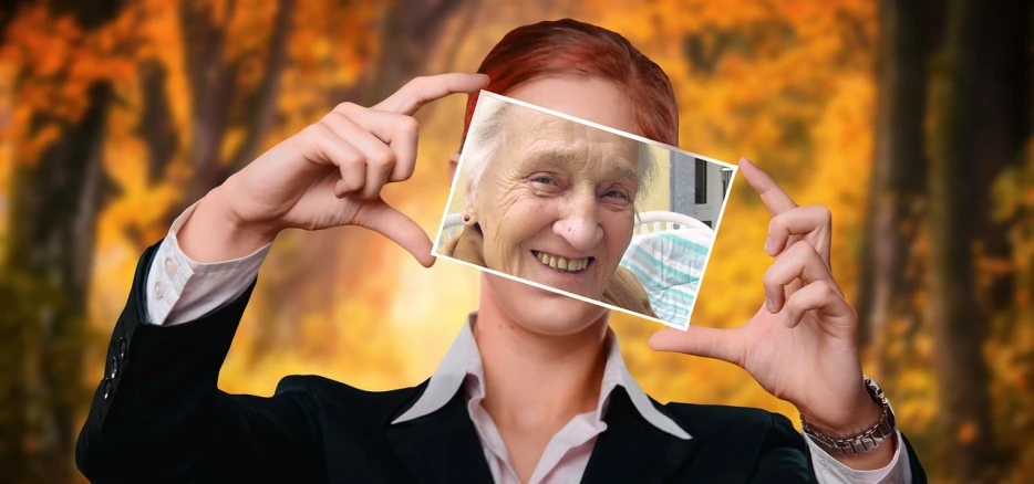 a woman holding a picture of herself in front of her face, by senior artist, pixabay contest winner, digital art, an oldman, while smiling for a photograph, woman with red hair, nursing home