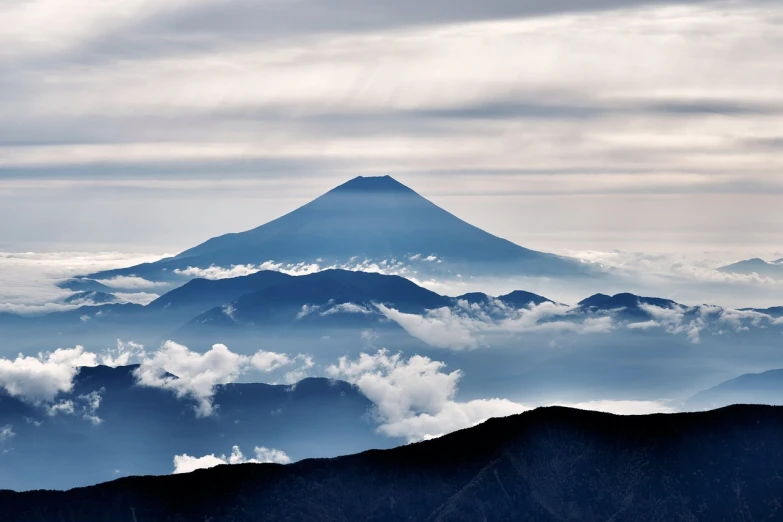 a mountain in the distance with clouds in the foreground, a picture, by Kaii Higashiyama, shutterstock, ffffound, that is 1300 feet tall, fuji, 600mm