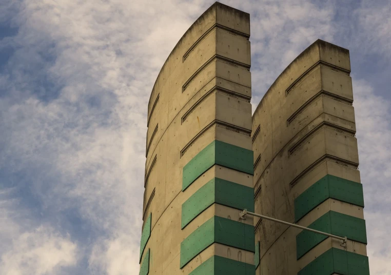 a tall building with a clock on top of it, a photo, inspired by Ricardo Bofill, brutalism, silo, cinematic view from lower angle, two towers, crisp lines and color