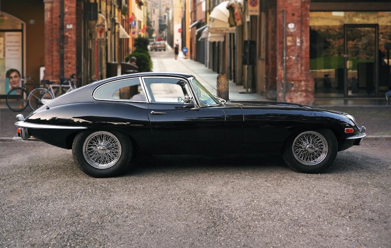 a black car parked on the side of a street, by Jay Hambidge, pexels contest winner, photorealism, jaguar e - type, 8k restored and remastered, fan favorite, summer morning light