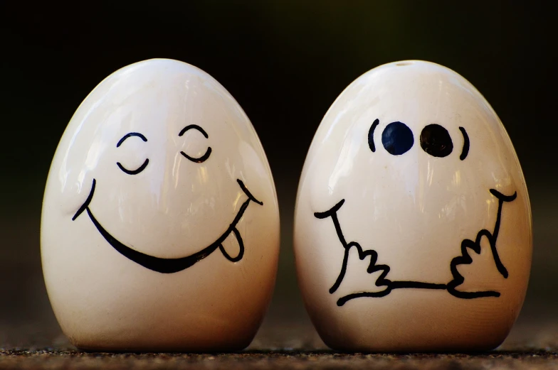 a couple of eggs with faces drawn on them, a picture, by Randy Post, trending on pixabay, minimalism, salt shaker, smiley face, stick figures, spherical