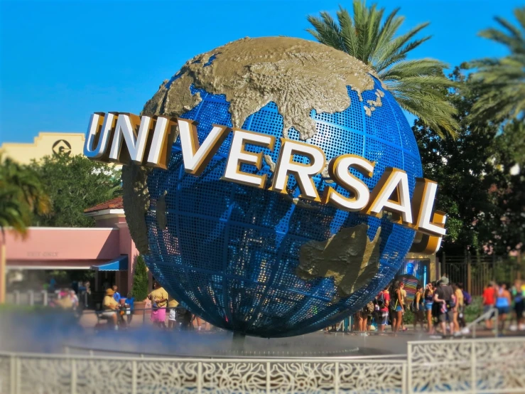 a large blue and gold globe sitting on top of a fountain, by Jeffrey Smith, unilalianism, hollywood promotional image, universal, amusement park buildings, crypto