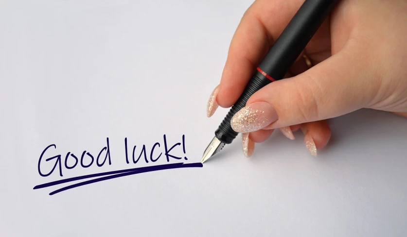 a person writing good luck on a piece of paper, by Pamela Drew, pixabay, hurufiyya, 😃😀😄☺🙃😉😗, highly detailed pen, cad, celebration