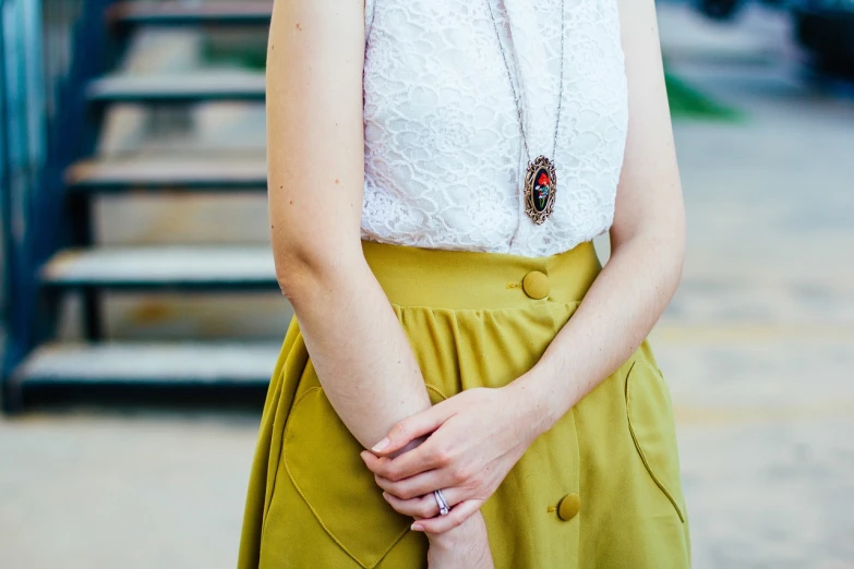 a woman in a white top and green skirt, pexels, detailed jewelry, 2 4 mm iso 8 0 0 color, yellow translucent lace, wearing business casual dress